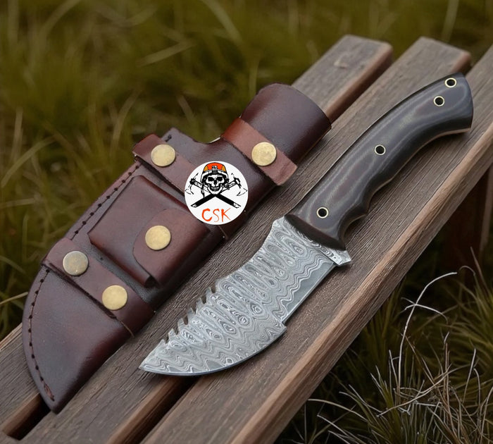 Bushcraft fixed-blade knife with patterned steel blade and textured G10-style handle