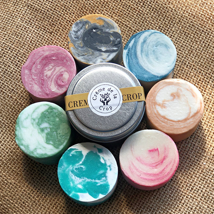 Assorted solid cleansing and shampoo bars displayed in tins, collection image for Soaps & Scrubs
