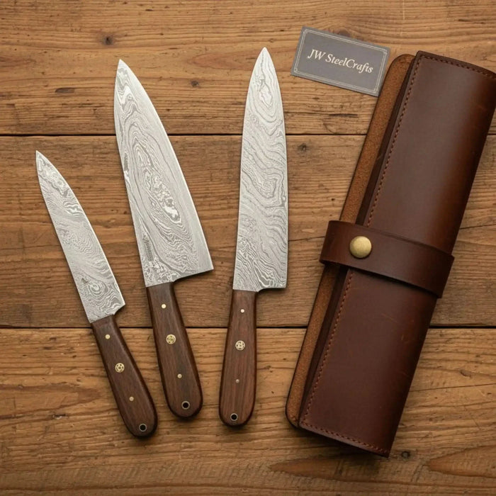 Three-piece kitchen knife set with bread knife, chef knife and paring knife with rosewood handles on a wooden table