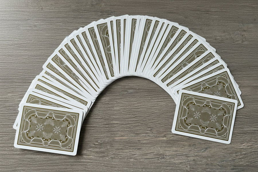 Fan of Gold Aristocrat card backs on a wooden surface