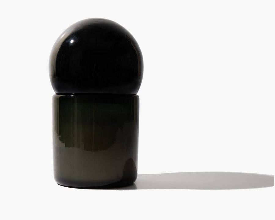 Dark glass Orb of Divinity candle casting a long shadow
