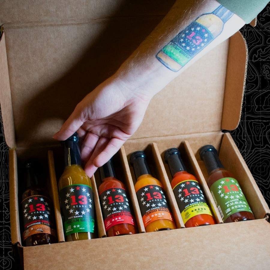Open hot sauce gift box with six bottles in cardboard dividers
