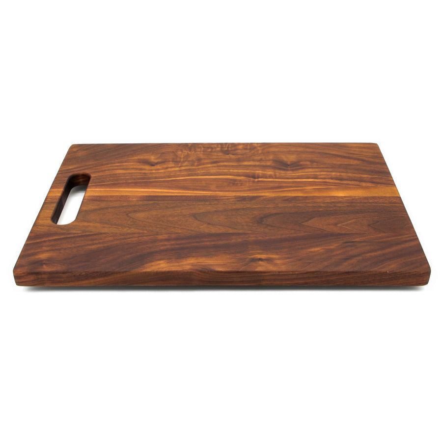 Compact walnut board with a single cutout handle, low angled view