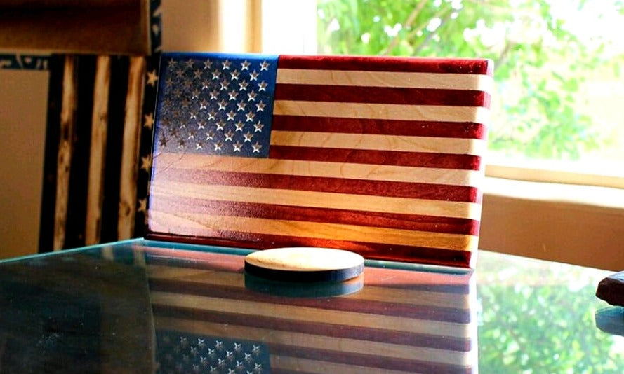 Young Glory wooden American flag displayed on a table beside a coaster