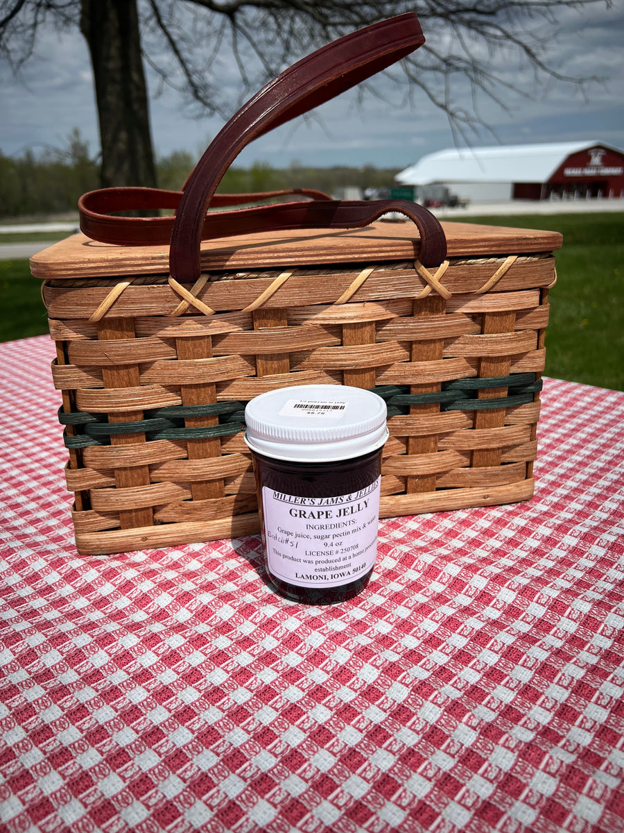 Miller’s Grape Jelly photographed beside a picnic basket outdoors