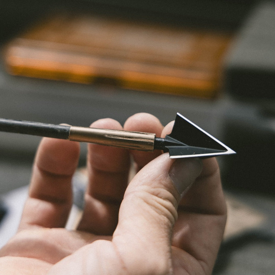 Three-blade broadhead mounted on an arrow held for inspection