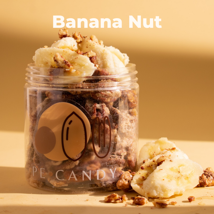 Banana Nut candied pecans in an open jar with muffin pieces on a gold background