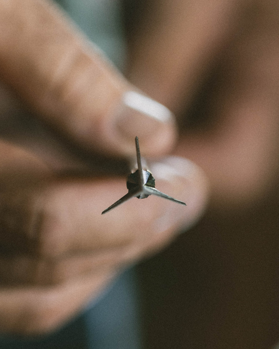 Front view of a three-blade broadhead held by its ferrule