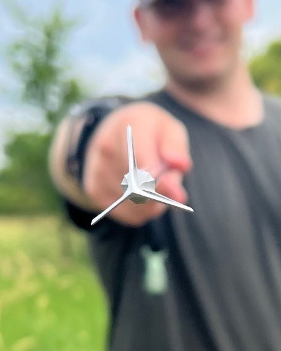 Front view of a stainless three-blade broadhead held for inspection