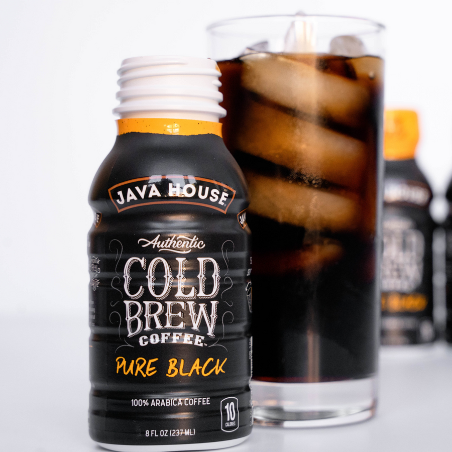 Pure Black bottle beside a glass of iced coffee
