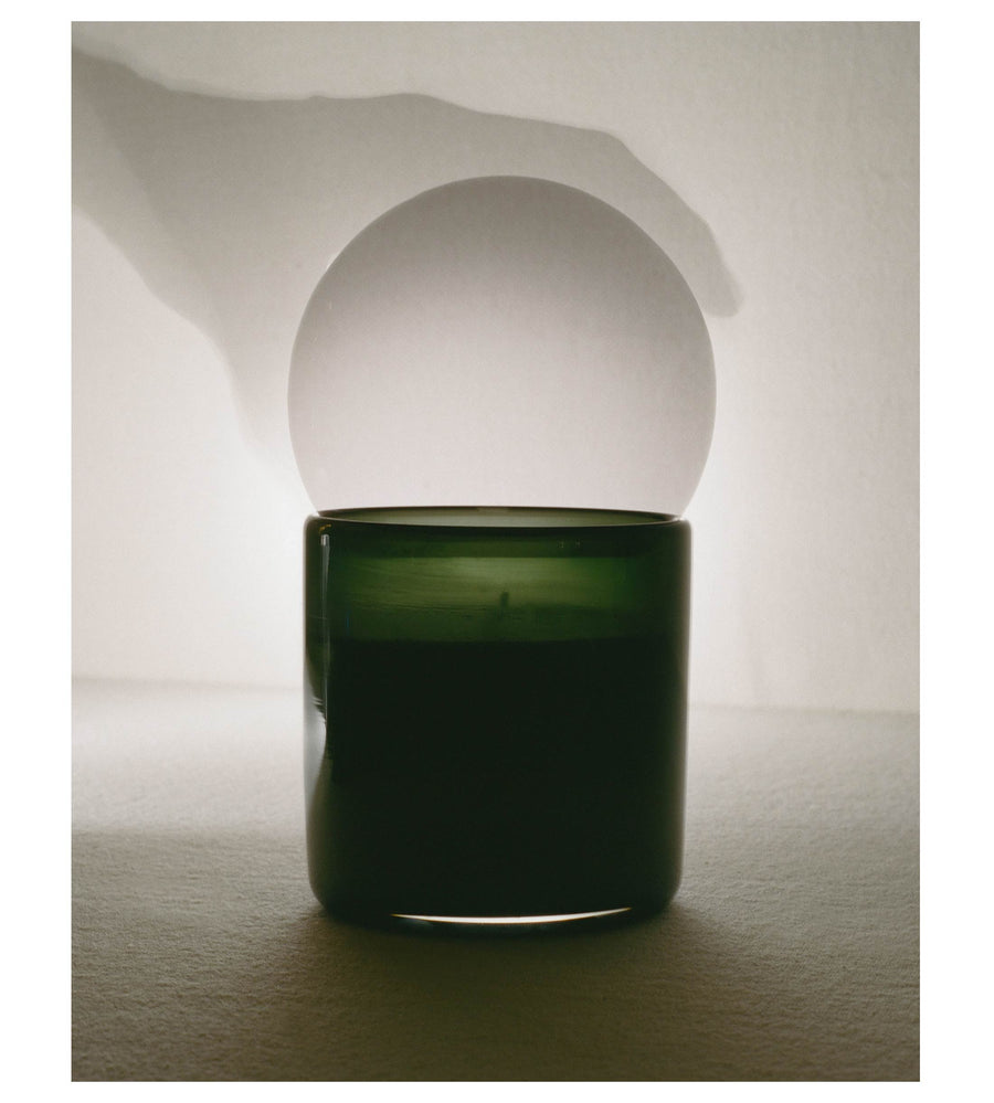 Open candle vessel with a pale reflection of the orb behind it
