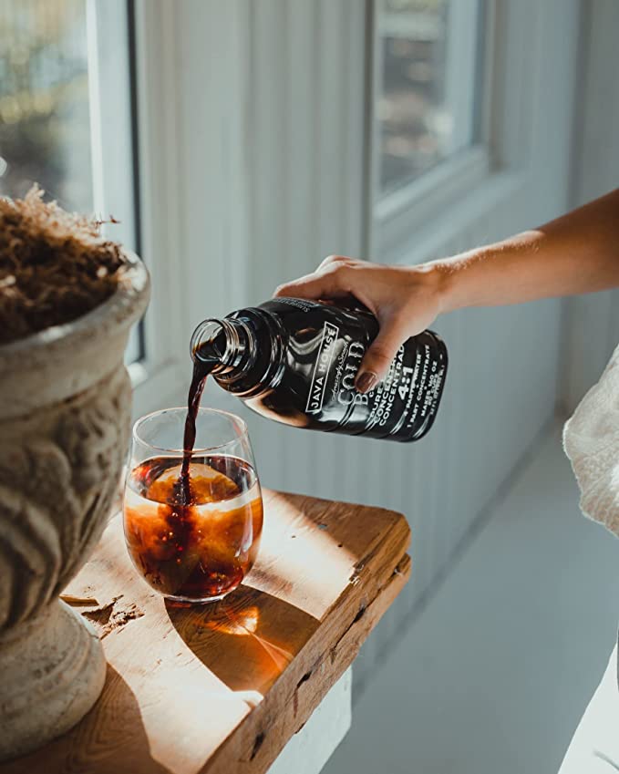 Person pouring concentrate into an iced drink