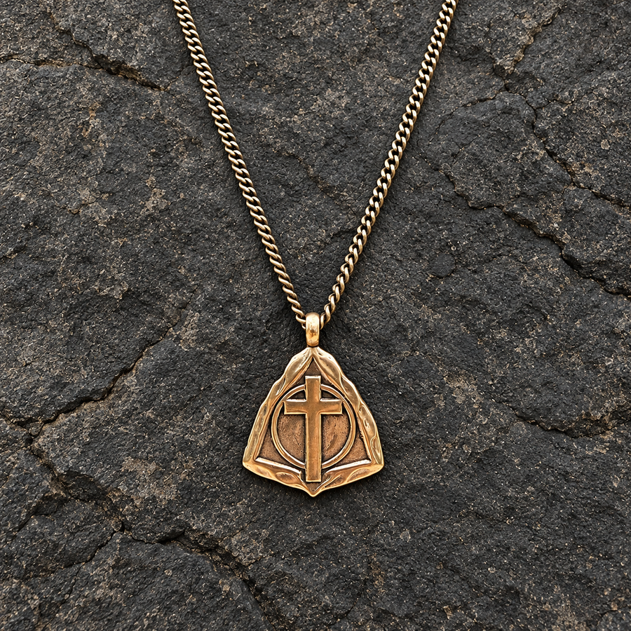 Resurrection Cross pendant on curb chain against dark stone