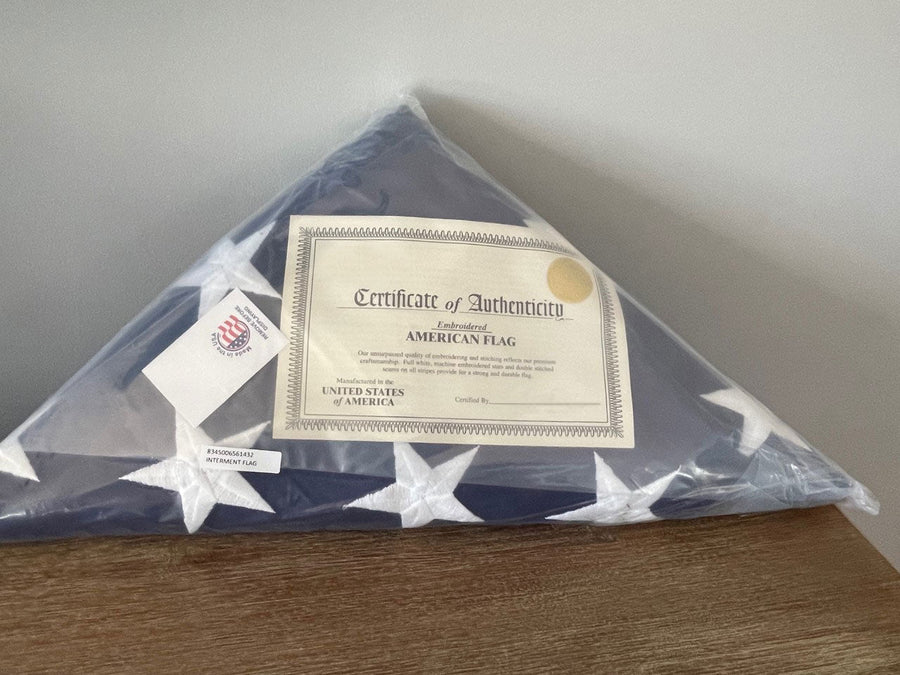 Pre-folded American burial flag with certificate of authenticity in protective packaging