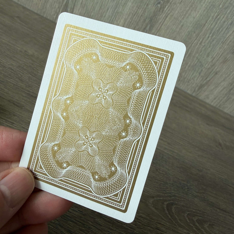 Gold Aristocrat card back held above a wooden surface