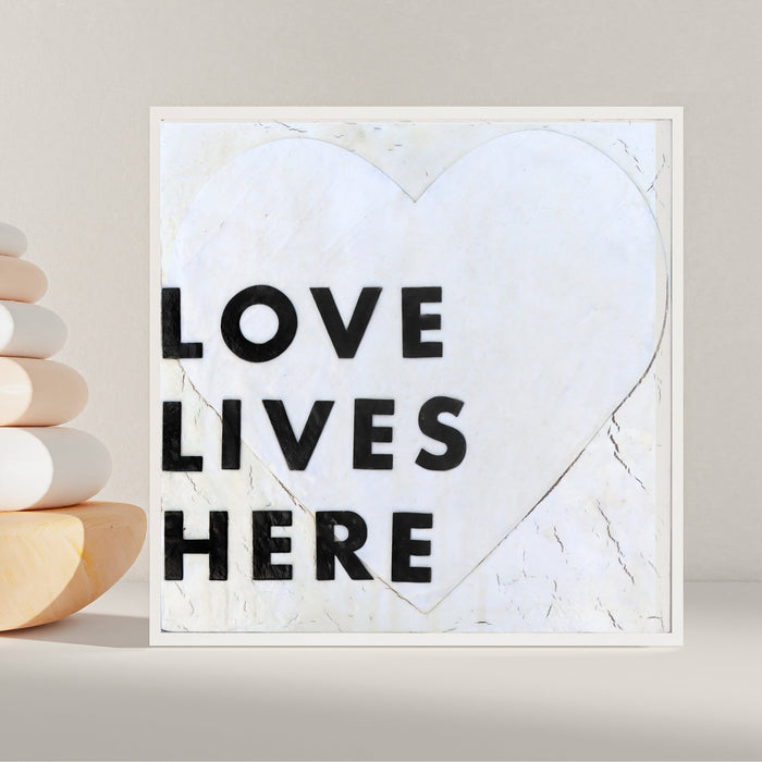 Love Lives Here art print with bold black lettering inside a heart outline.