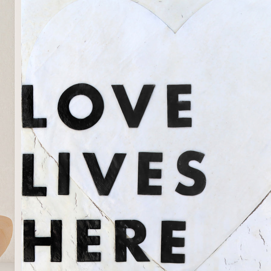 Love Lives Here art print with bold black lettering inside a heart outline.