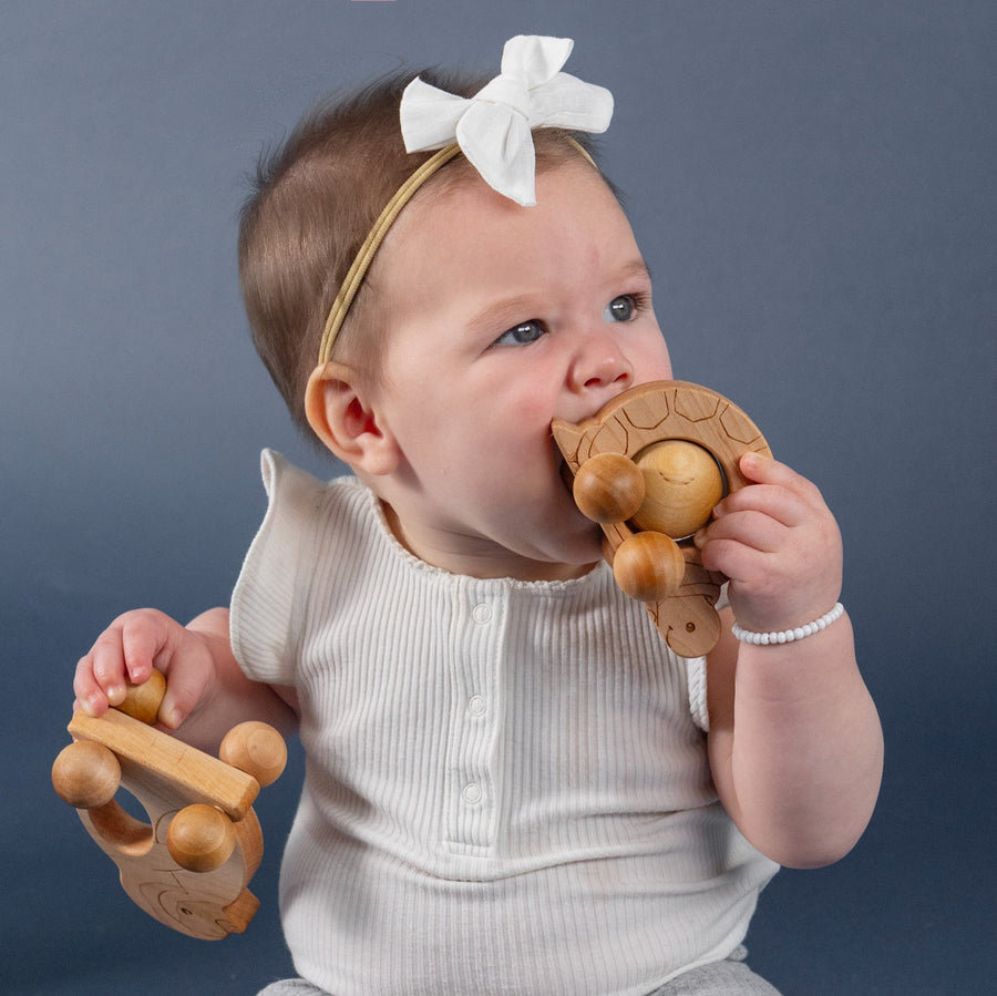 Children exploring wooden animal push toys with spherical wheels