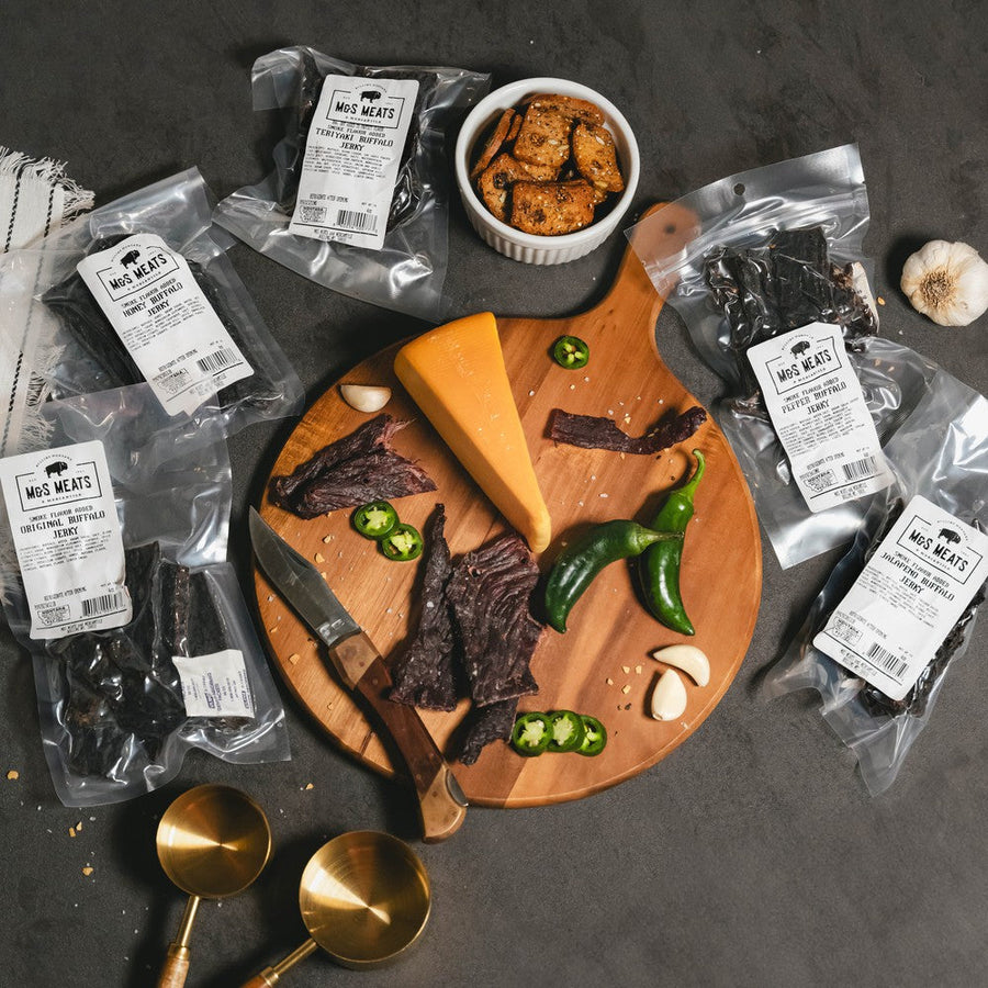 Buffalo Jerky Sampler, five jerky bags surrounding a serving board