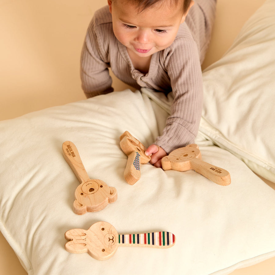 Bunny-shaped wooden rattle and striped discovery mirror during play