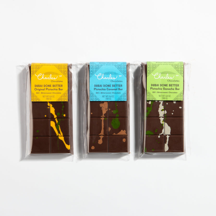 Three wrapped pistachio Dubai bars in original, caramel, and dark ganache flavors