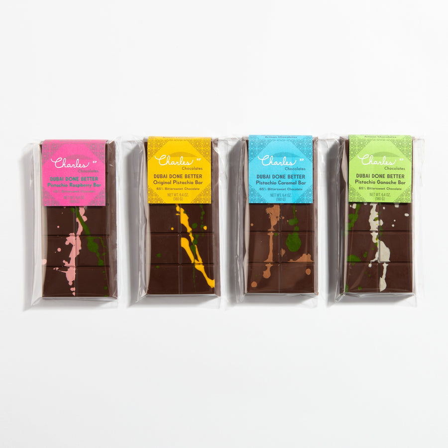 Four wrapped Dubai chocolate bars in raspberry, original, caramel, and ganache flavors