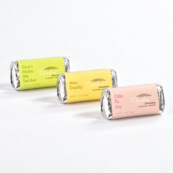 Three wrapped Nostalgia chocolate bars in peanut, almond, and macadamia flavors