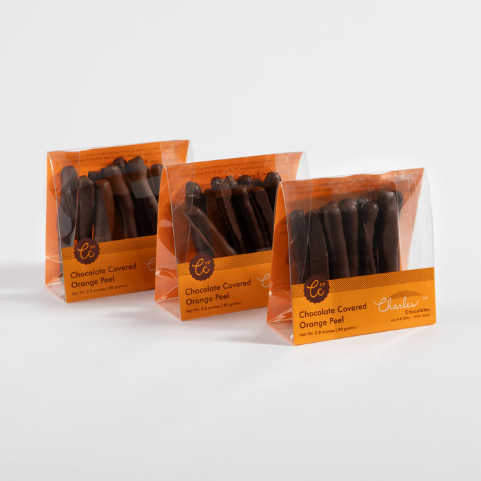 Three packages of dark chocolate-covered Valencia orange peel