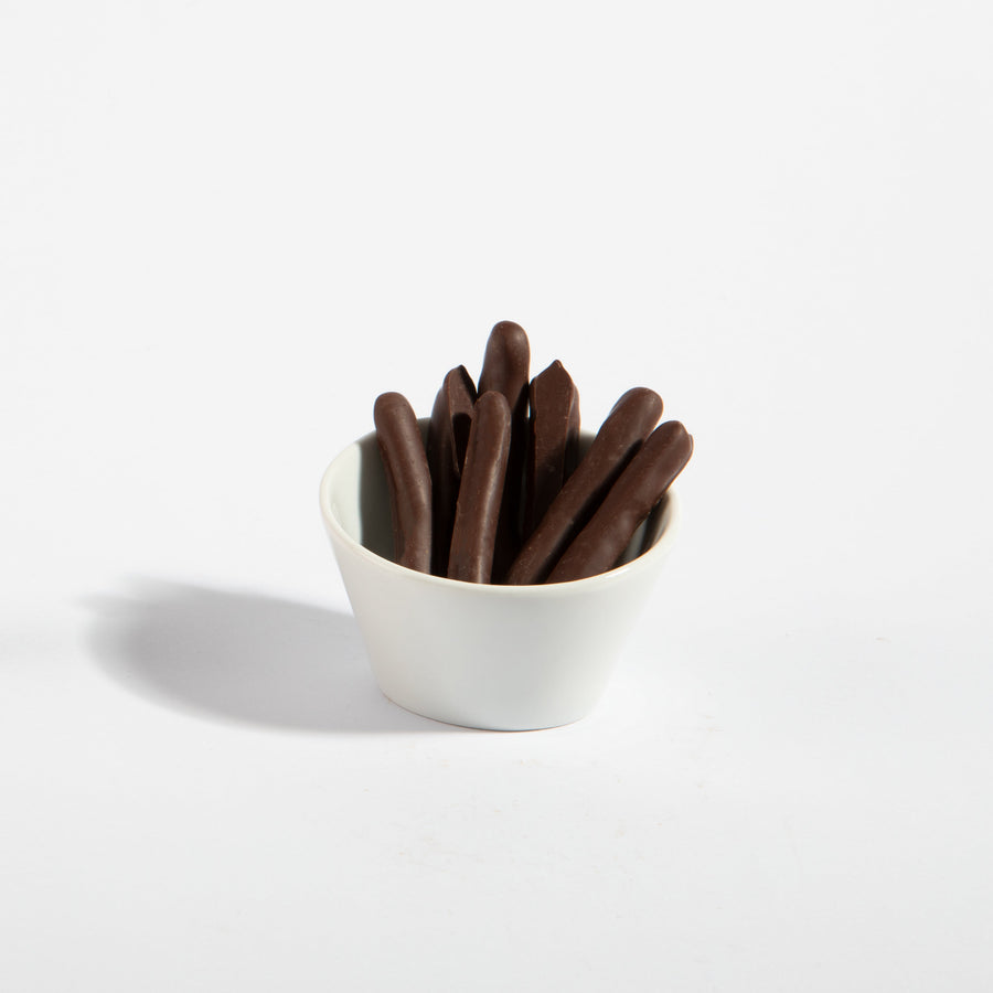 Dark chocolate-covered orange peel strips in a white serving bowl