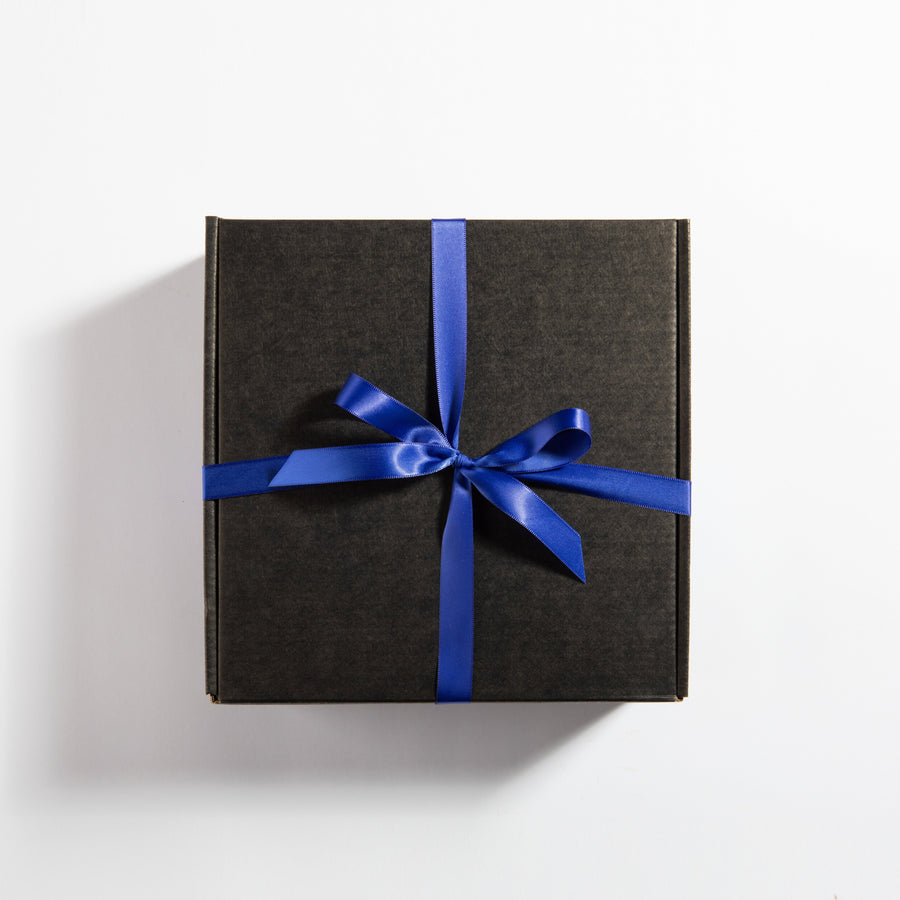 Closed black smores gift box tied with a blue ribbon