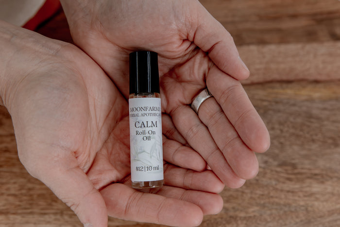 Hand holding a Calm botanical roll-on oil