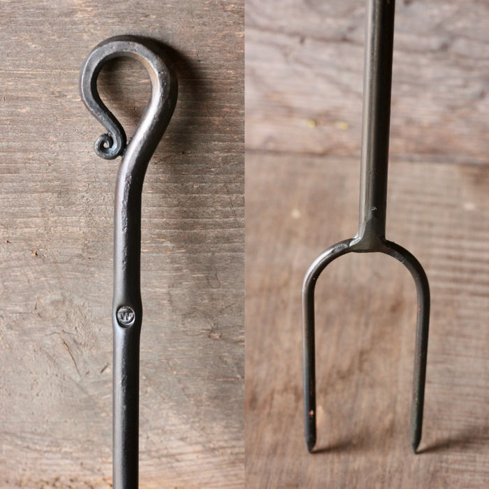 Curled handle and prong of a hand-forged campfire roaster