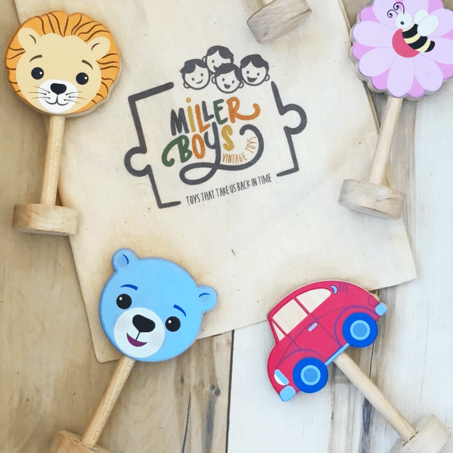 Assorted wooden baby rattles arranged with a cotton storage bag