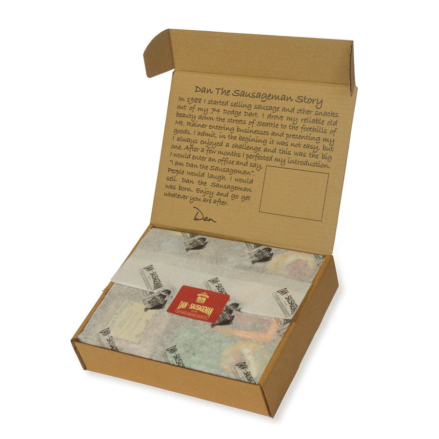 Open kraft gift box with printed tissue paper and red gift tag