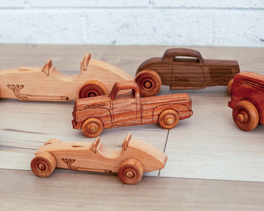 Children playing with an assortment of wooden cars, trucks and airplanes