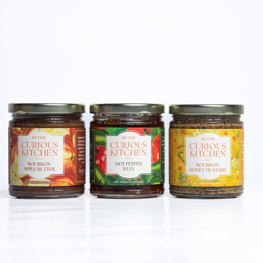 Three condiment jars: bourbon apple butter, hot pepper jelly and honey mustard