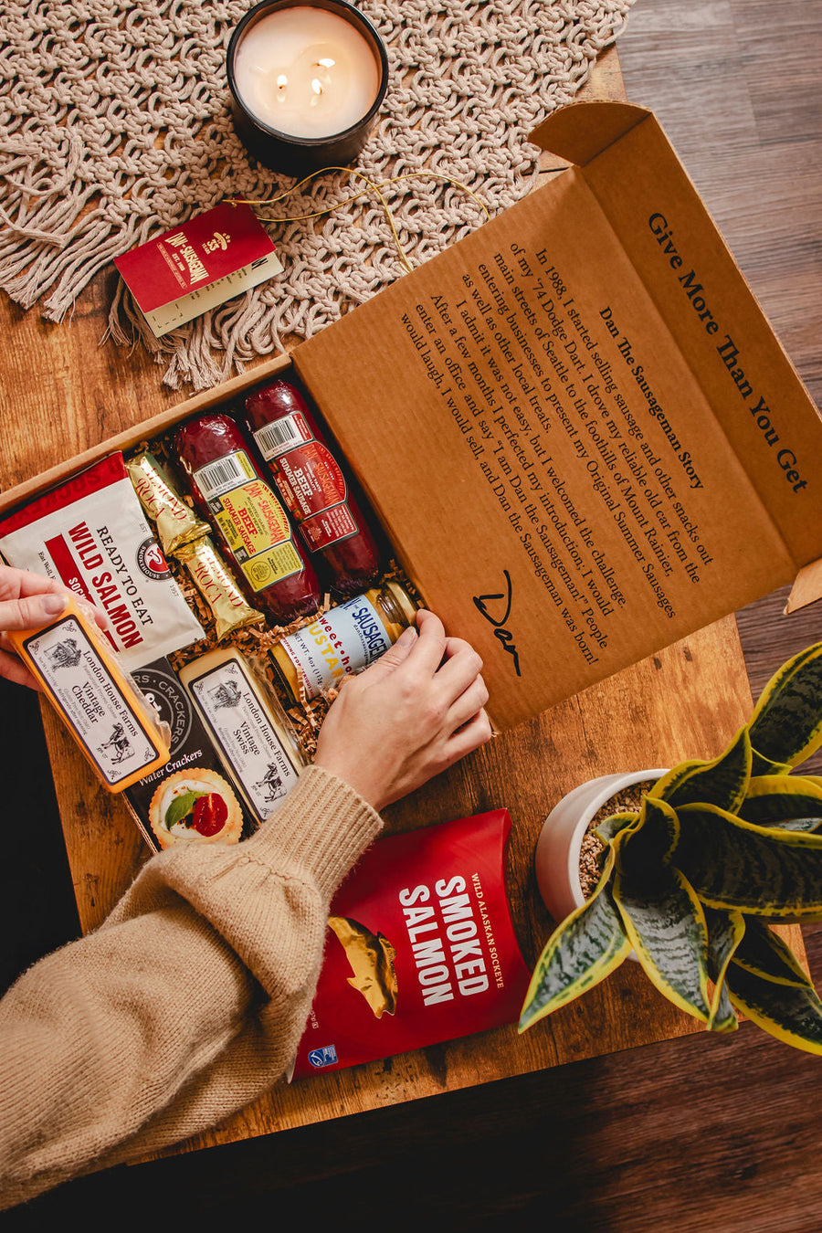 Open Chinook gift box showing wrapped sausage, cheeses, salmon and snacks