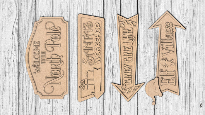 Four unfinished North Pole-themed directional MDF sign pieces
