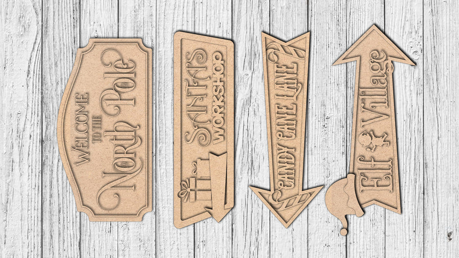Four unfinished North Pole-themed directional MDF sign pieces