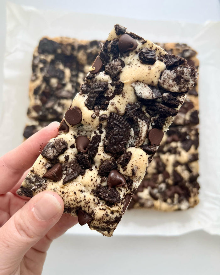 Cookies & Cream Blondies — a blondie held to show the cookie pieces inside
