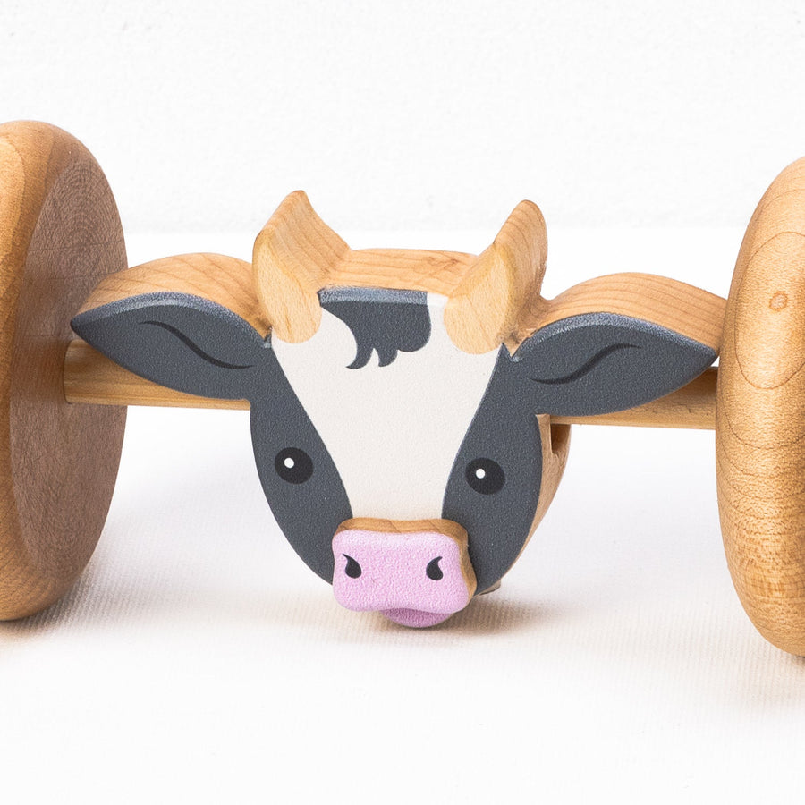 Cow-face detail on a wooden rolling animal toy