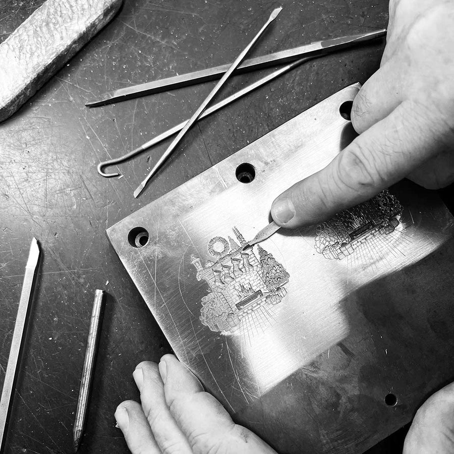 Artisan shaping and engraving metal with hand tools