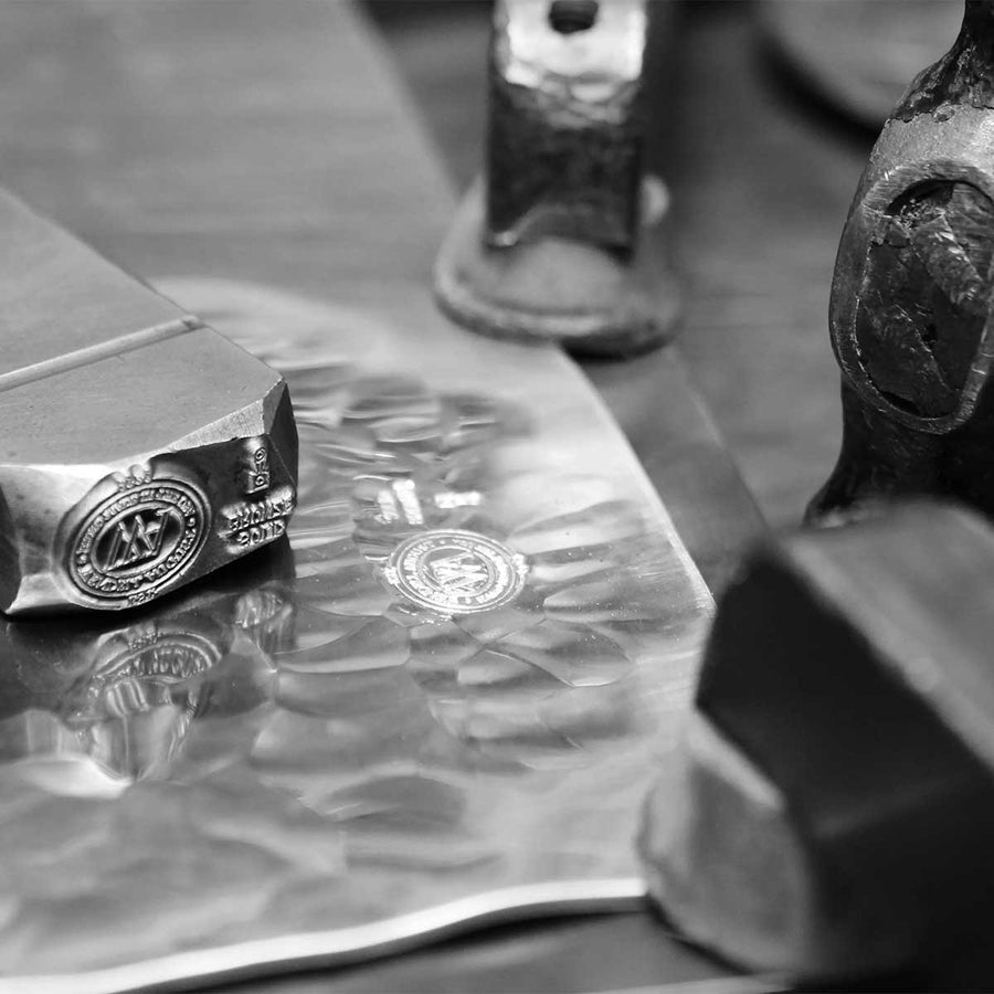 Artisan shaping and engraving metal with hand tools