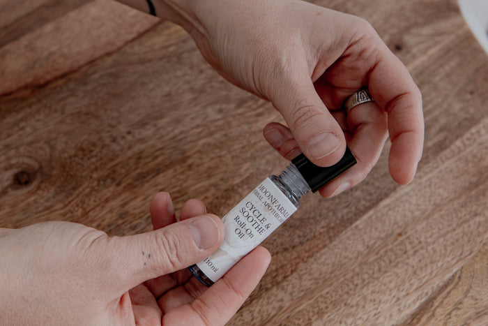 Hands holding the Cycle and Soothe roll-on oil