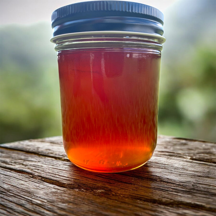 Glass jar of lavender-infused honey with a dark screw-top lid