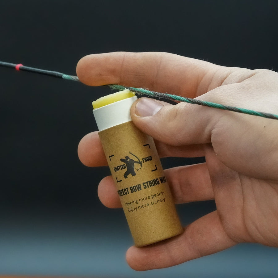 Sticky Perfect Bowstring Wax — hand holding push-up wax tube