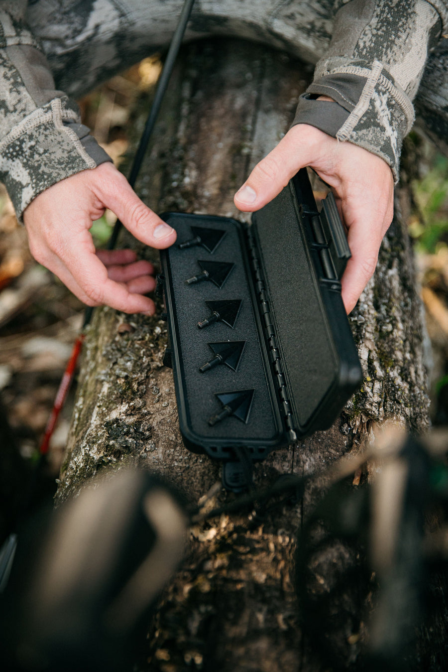 Open black broadhead case held outdoors