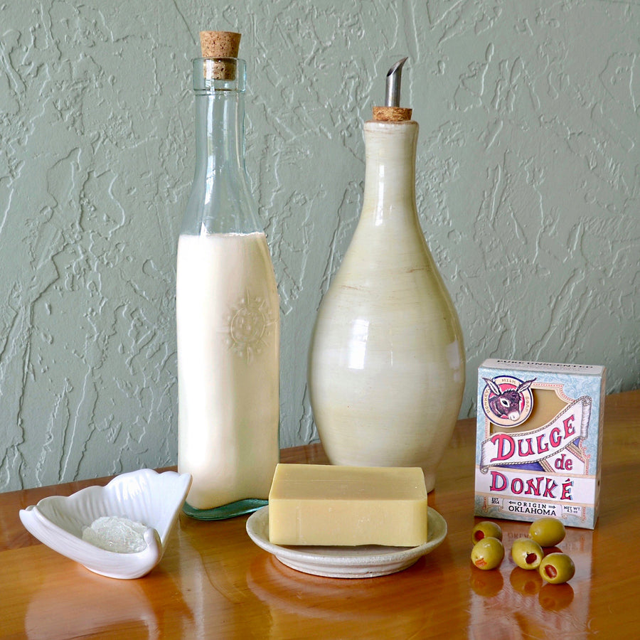 Unscented soap, box, and milk bottles arranged on a wooden table