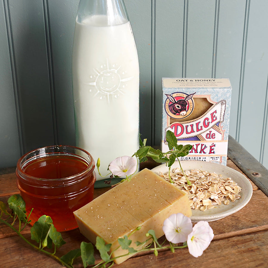 Oat and honey soap with a honey jar, oats, milk bottle, and package