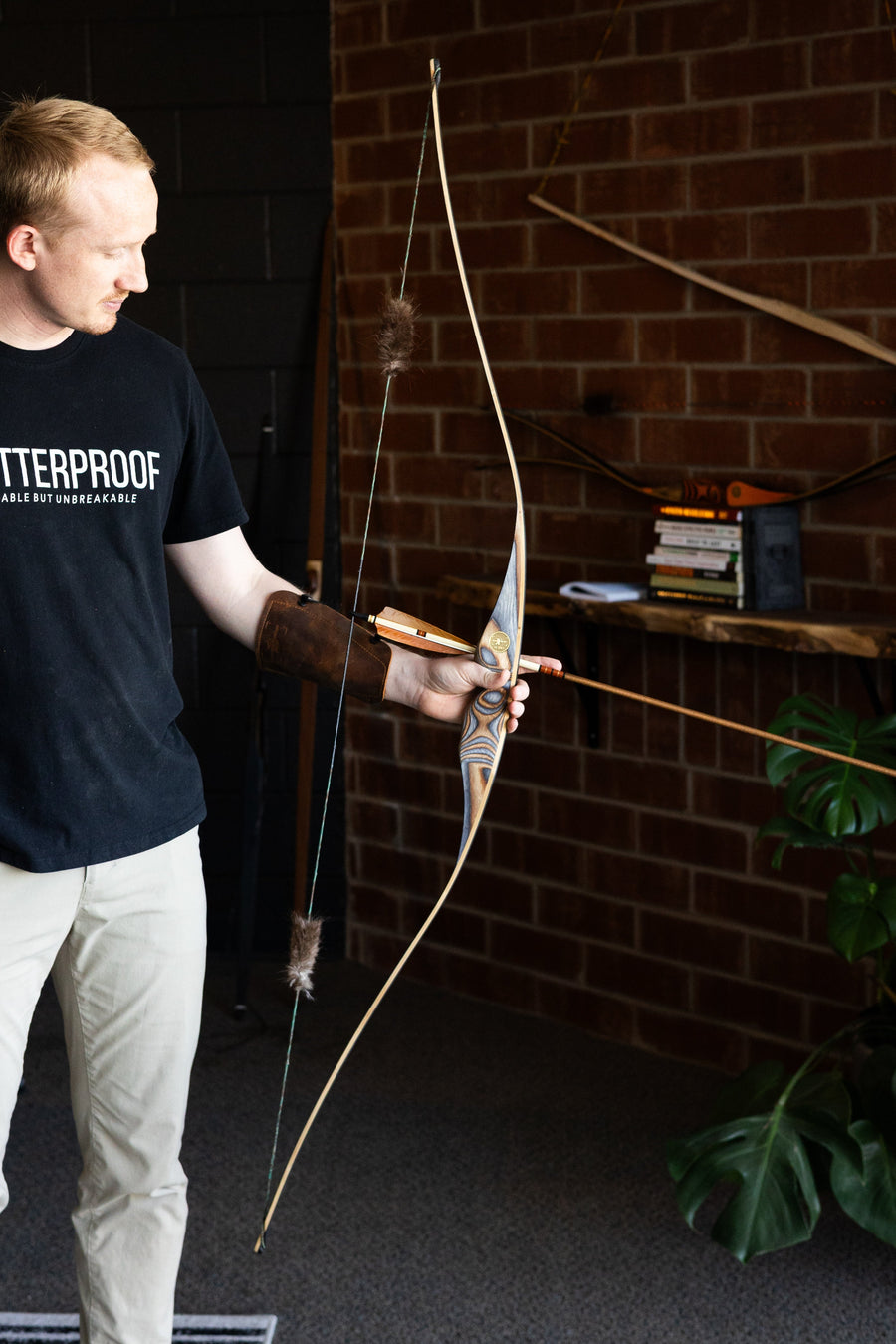BONES Reflex-Deflex Longbow — archer holding bow in workshop